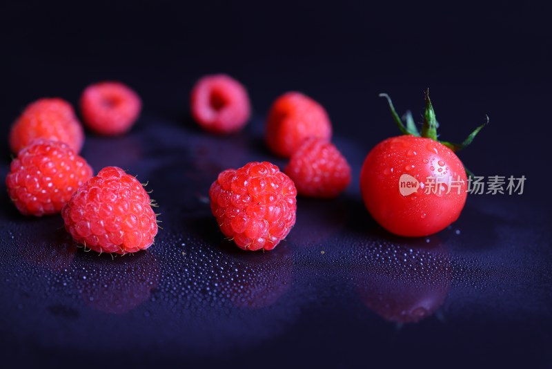 黑色背景下的树莓和小番茄特写镜头