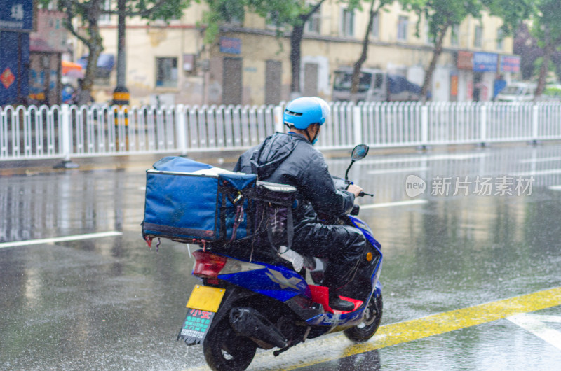 下雨天，马路上一位送外卖的外卖员