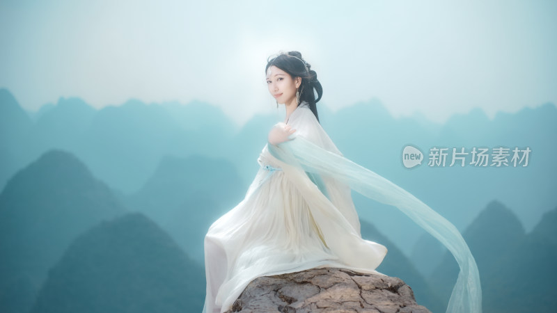 古装女子坐于山石背景前