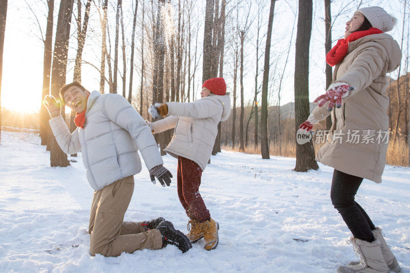 在雪地上玩耍的一家三口