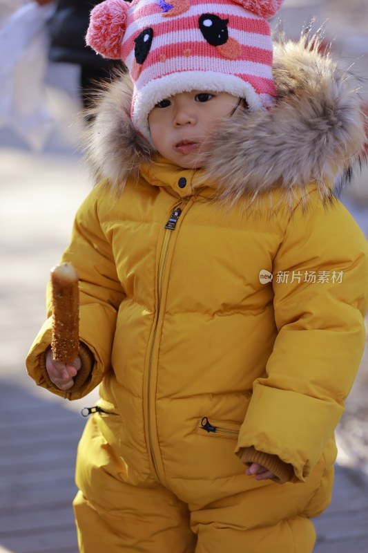 雪地中穿着厚衣的幼儿