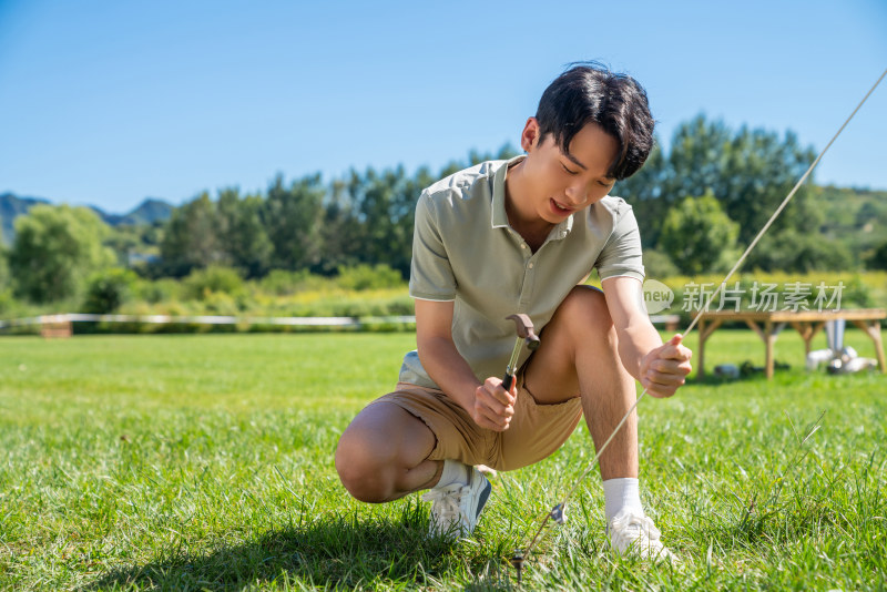 男孩在露营地搭建帐篷