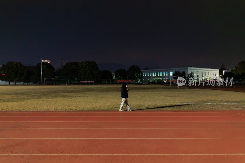 夜晚操场单人漫步场景