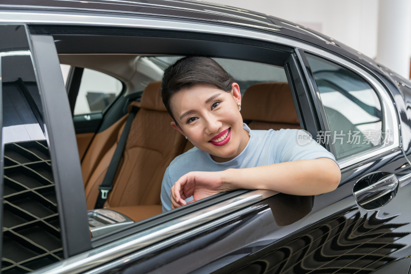 年轻女子坐在汽车后座