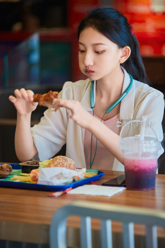 在商场快餐厅大吃特吃的中国可爱少女人像