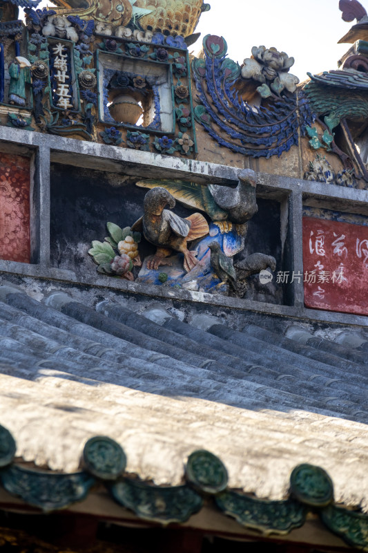 岭南传统民居建筑墙上雕刻着彩色的石刻