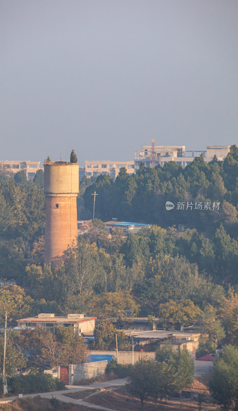 树林中的老式水塔与建筑远景