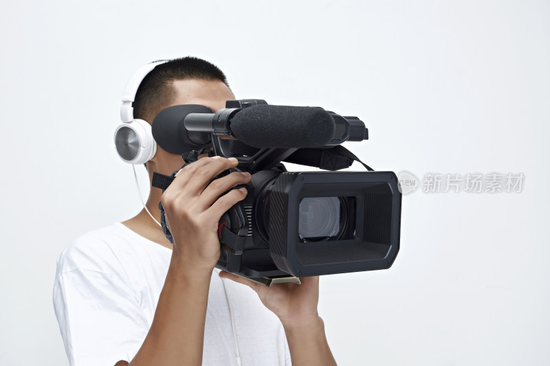 白色背景下手持摄像机进行录制拍摄的摄像师