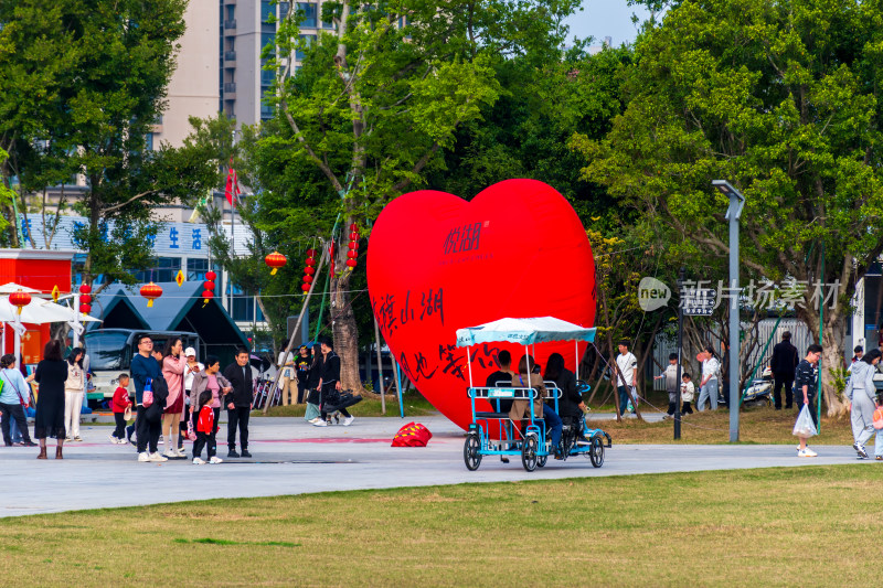 广场上的红色爱心雕塑与人流