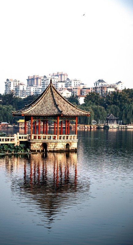 济南大明湖九曲亭湖边中式亭子与城市背景