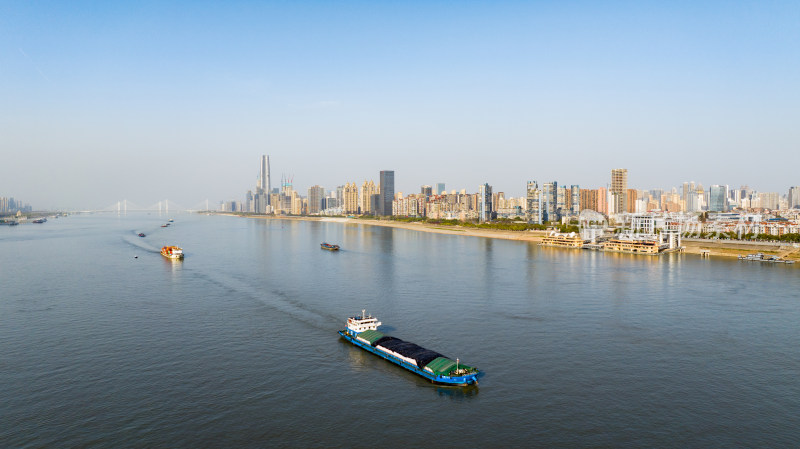 城市江面上的货船与沿岸高楼景观