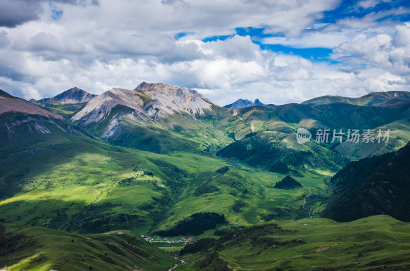 蓝天白云下广袤草原与连绵山峦自然风景