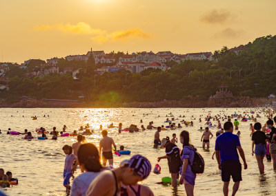 青岛汇泉湾夕阳下，海滩的人们