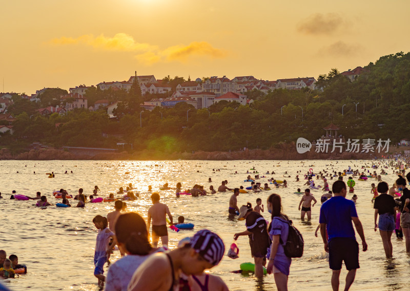 青岛汇泉湾夕阳下，海滩的人们