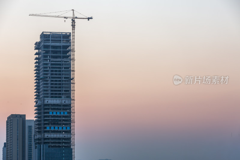 日幕时分正在建设中的高楼摩天大楼与塔吊