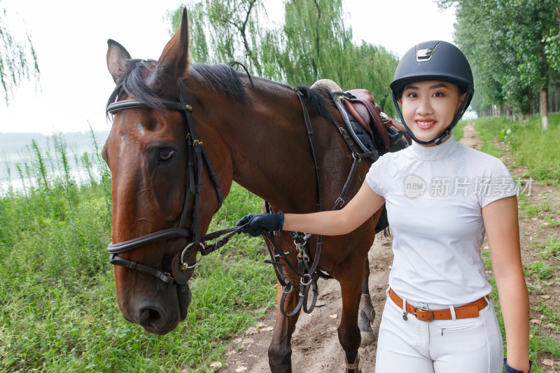 林间小路漂亮的年轻女孩牵着马