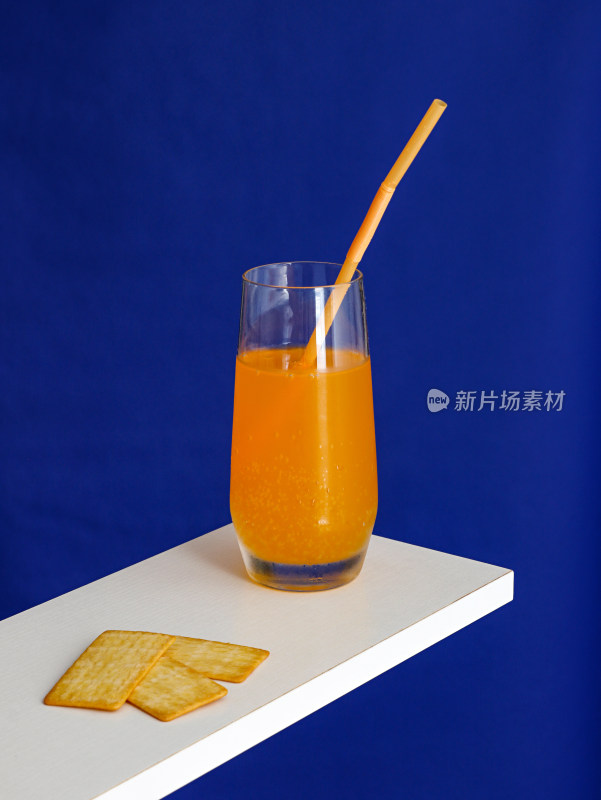 蓝色背景，桌面上摆放着饼干和夏日饮品果汁