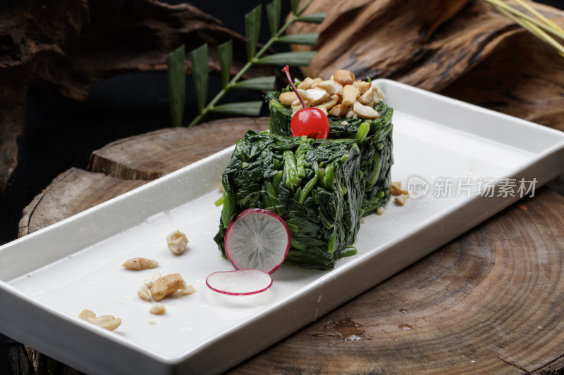 长方形瓷盘装的菠菜卷摆放在樟木砧板上