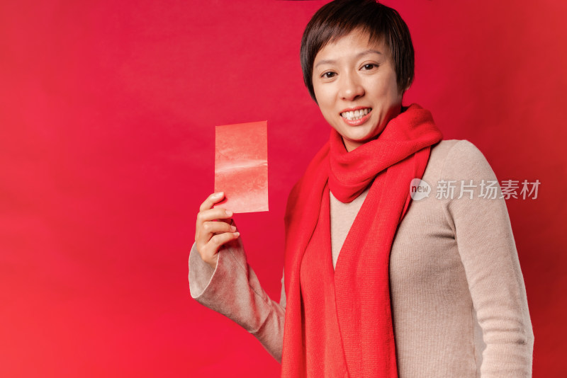 站在红色背景前拿红包的中国女性