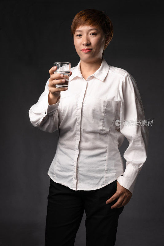 穿白色衬衫喝水的年轻中国女性
