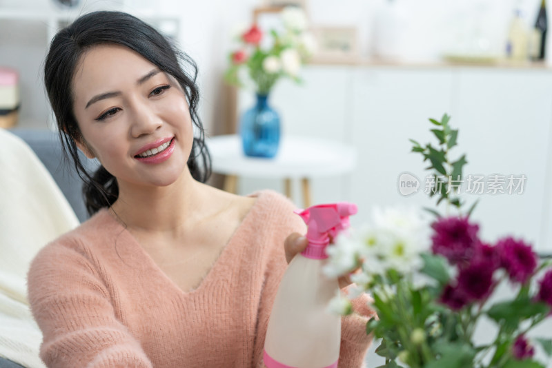 年轻女子在家浇花