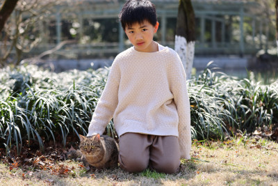 一个中国小男孩和他的宠物猫狸花猫