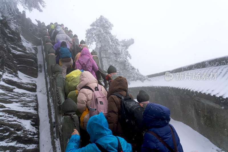 寒冷冬天大雪中攀登台阶的游客