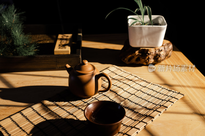 午后阳光照在摆着紫砂壶的木质桌子上