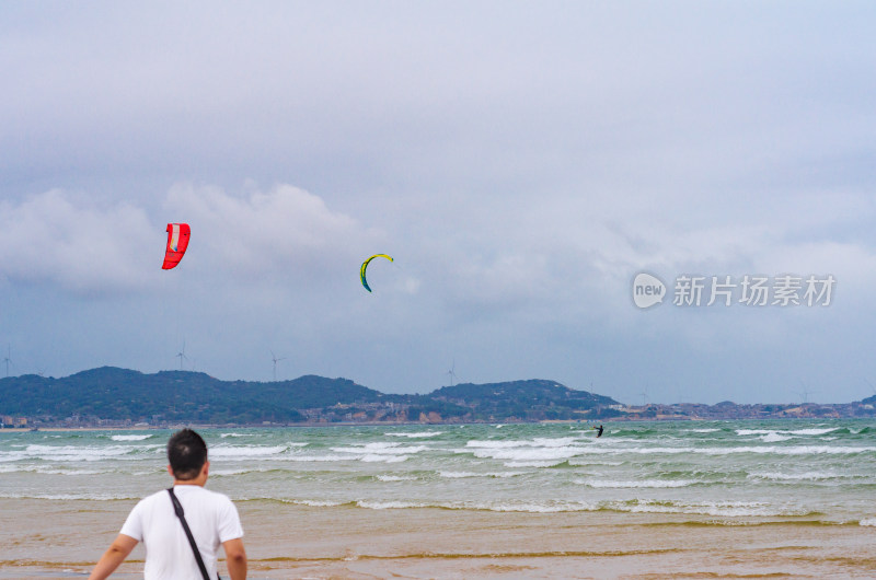 男子海边观看风筝冲浪运动