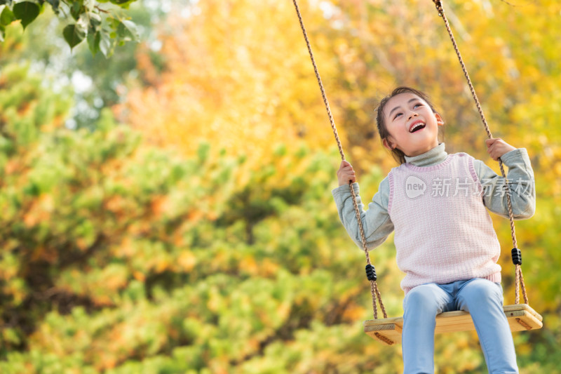 快乐的小女孩在公园里荡秋千