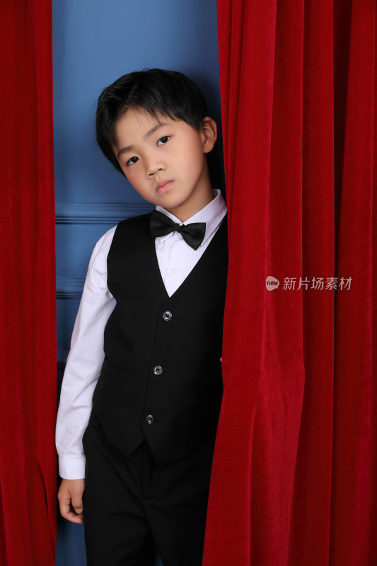 一个穿黑色西装的时尚中国小男孩