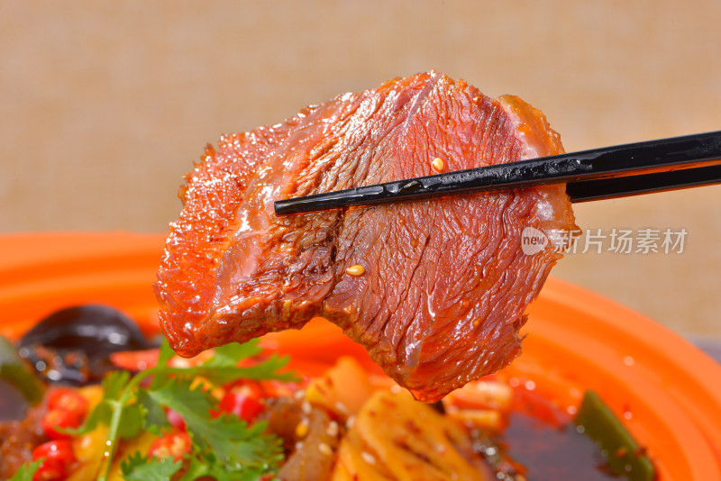 筷子夹起美味牛肉的诱人餐饮画面