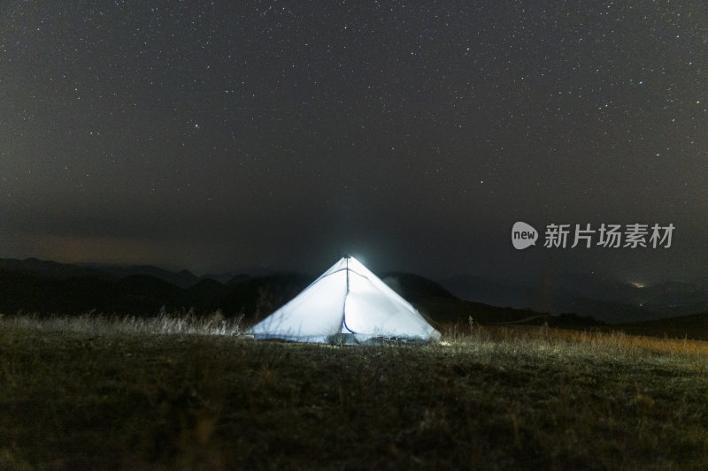 户外草地夜晚亮灯帐篷与星空的景象