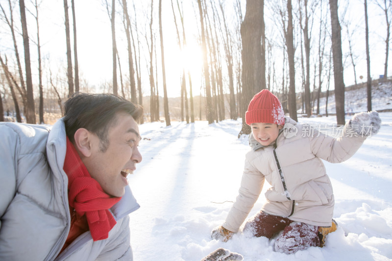 在雪地上玩耍的快乐父子