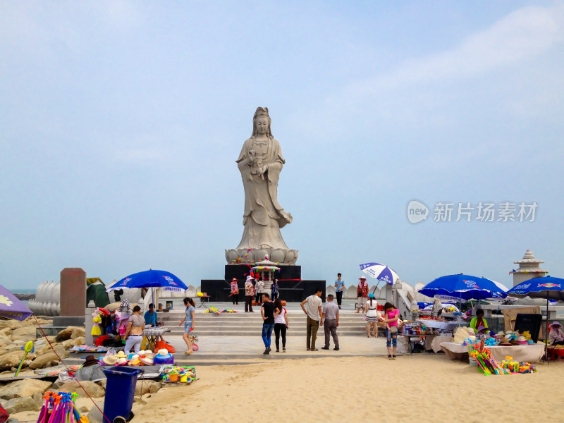 海边观音雕像游客及摊贩场景