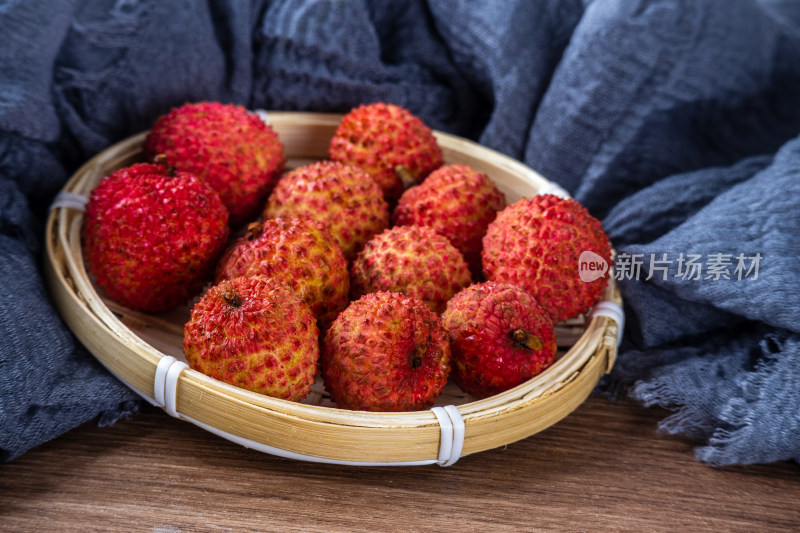 桌面上篮子里装着刚采摘下来的新鲜桂味荔枝