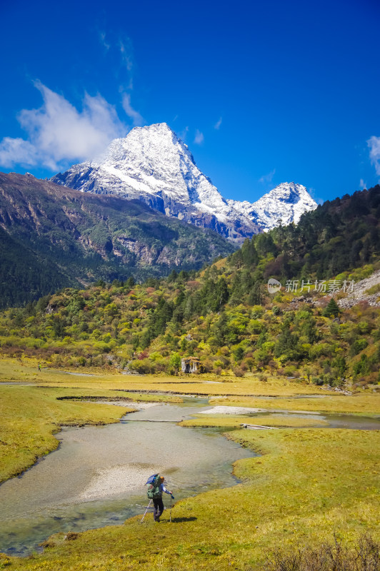 雪山脚下背包旅行者