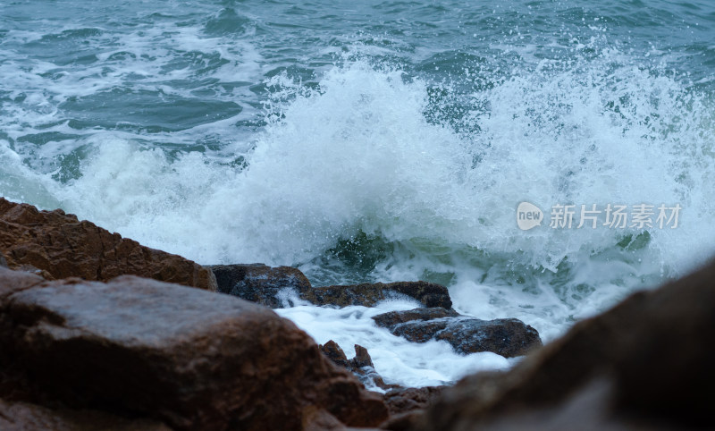 低机位抓拍海浪冲击岩石的瞬间