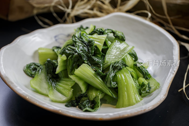 浪花边瓷盘装的炝炒油菜