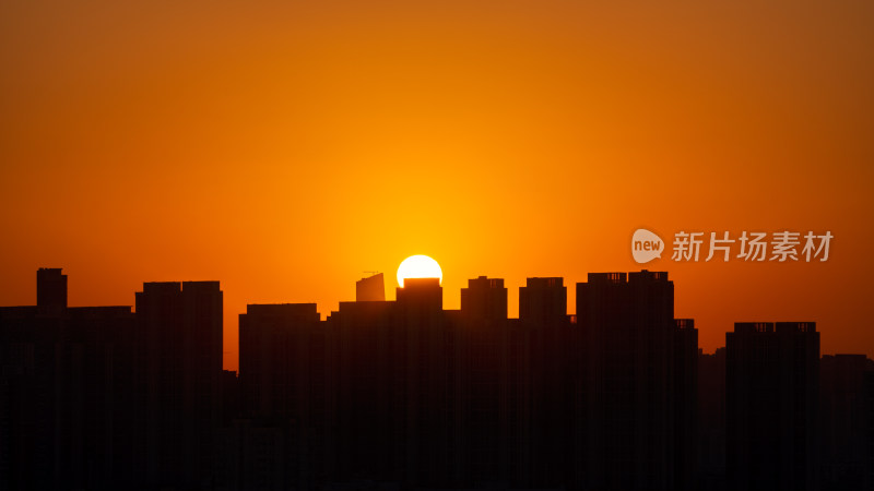 清晨城市高层住宅与日出太阳