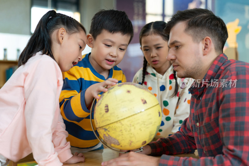 外籍老师教孩子辨认地球仪