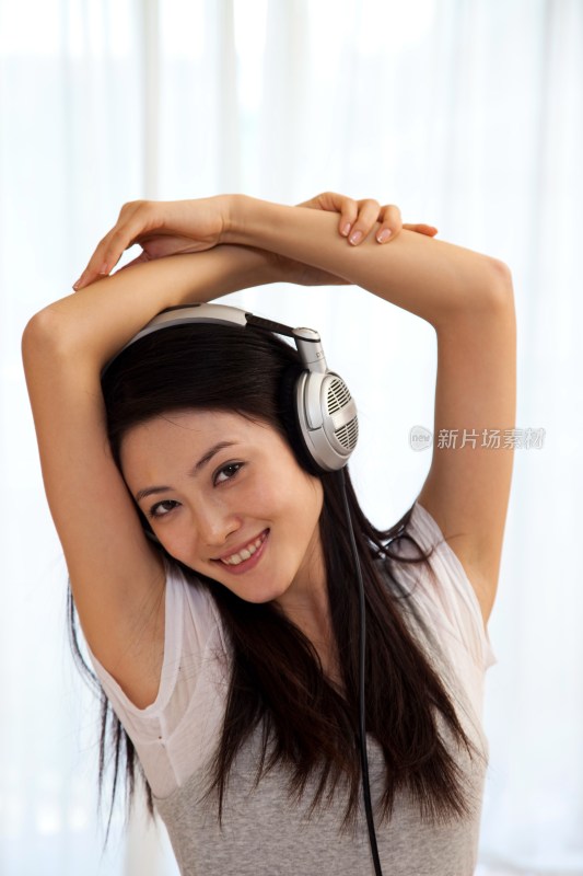 年轻女人戴耳机听音乐