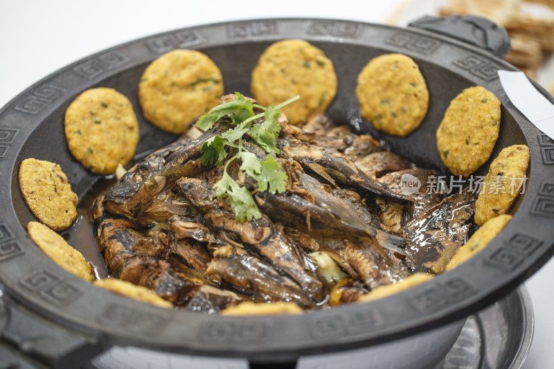 精美铁锅装的传统名菜熬杂鱼贴饼子