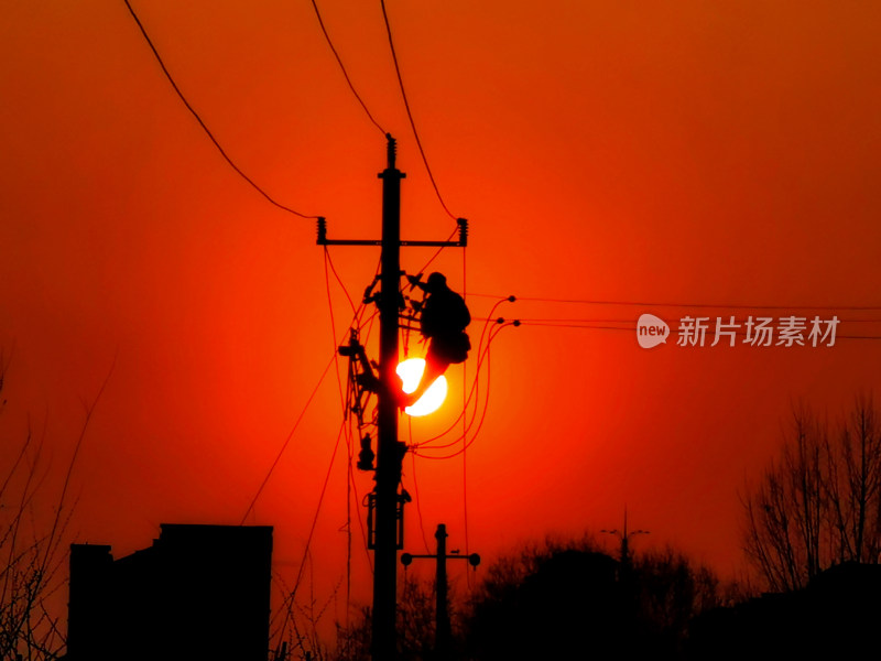 电力工人夕阳下电杆上工作场景