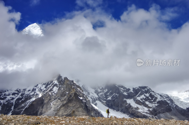 一个人站在雪山脚下自然风光