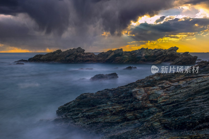 海岸边乌云下的岩石与海洋