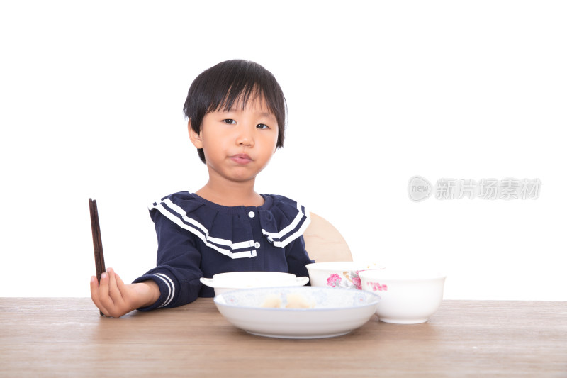 白背景前吃着饭连带卖萌的中国小女孩