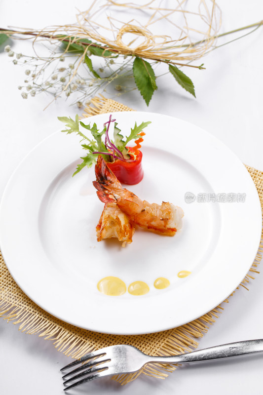 圆形白瓷盘装的铁板深海大明虾摆放在草垫上
