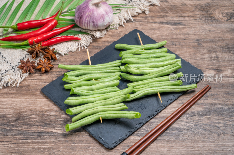 石板上串好的新鲜豆角串