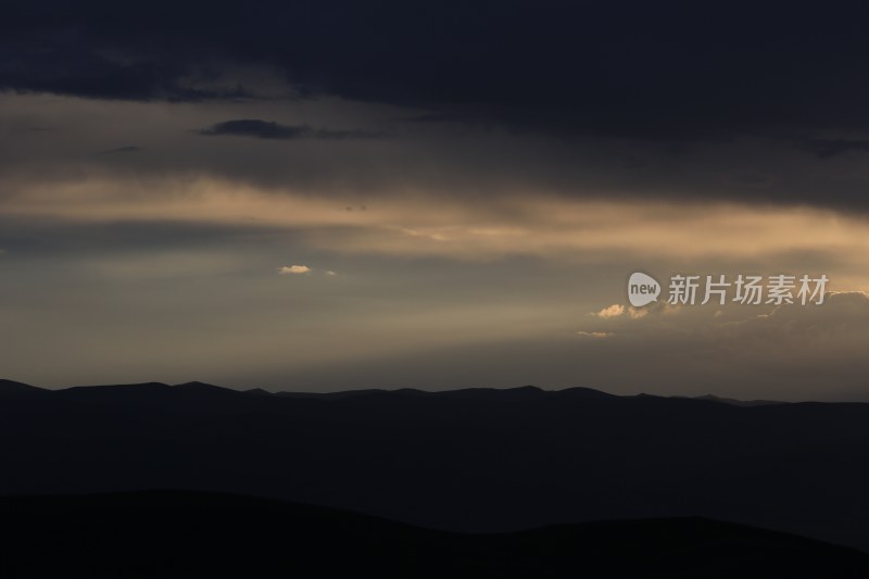 山峰日落时天空映衬的剪影景观